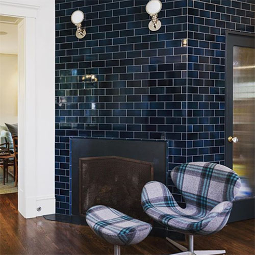 dark blue subway tile around a fireplace