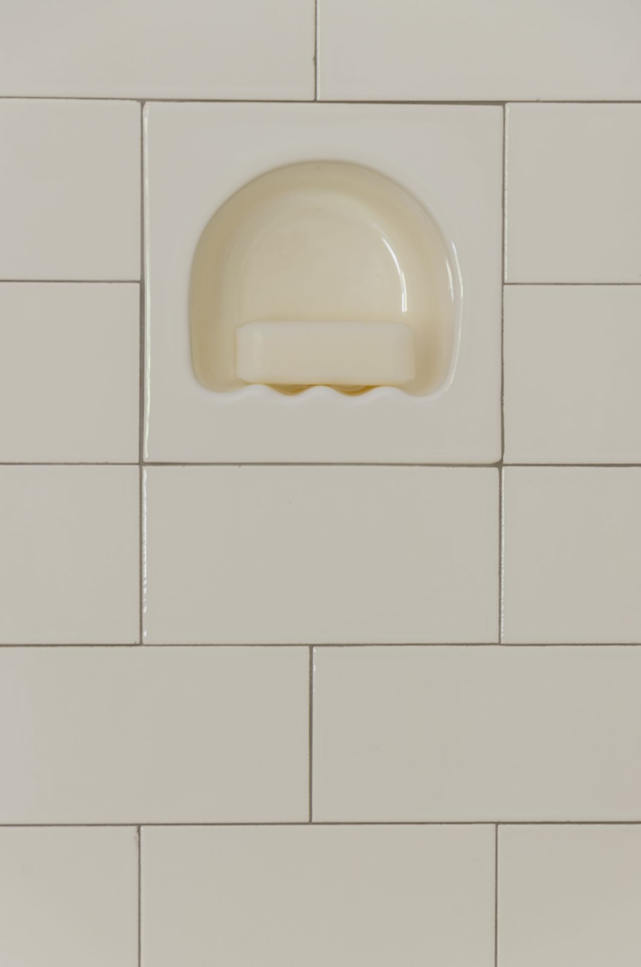 white subway tile on shower wall with recessed soap dish